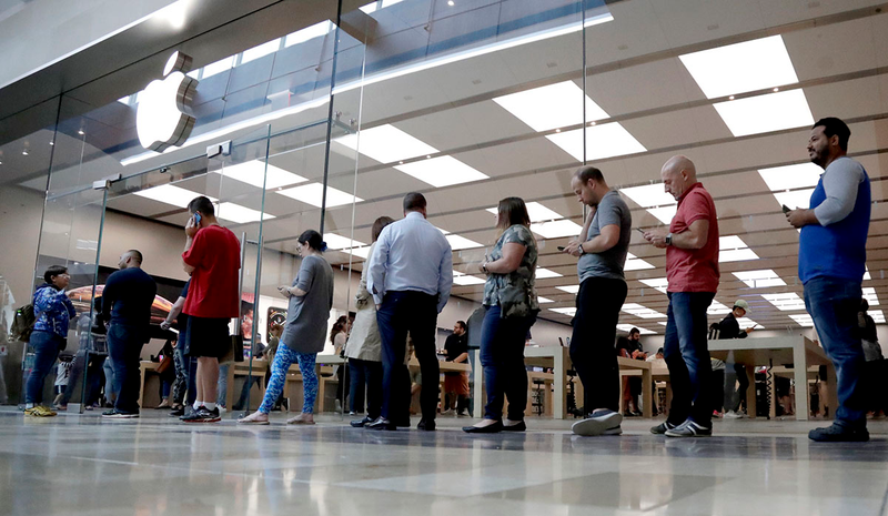 Personas haciendo cola en una Apple Store.